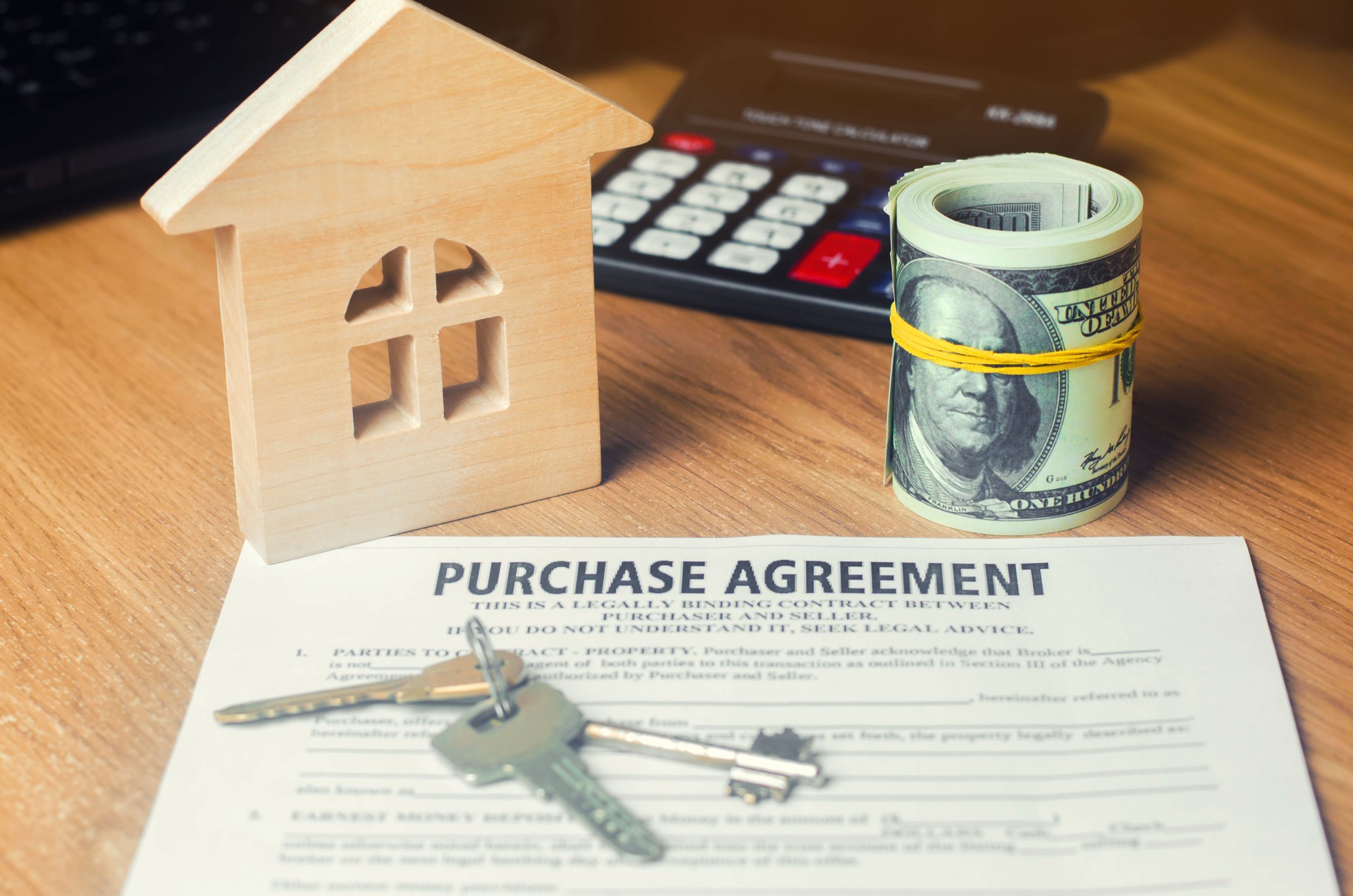 Contratto per l'acquisto di una casa. chiavi, modello di casa e dollari. Investimenti immobiliari. l'acquisto, l'affitto e la vendita di appartamenti.
